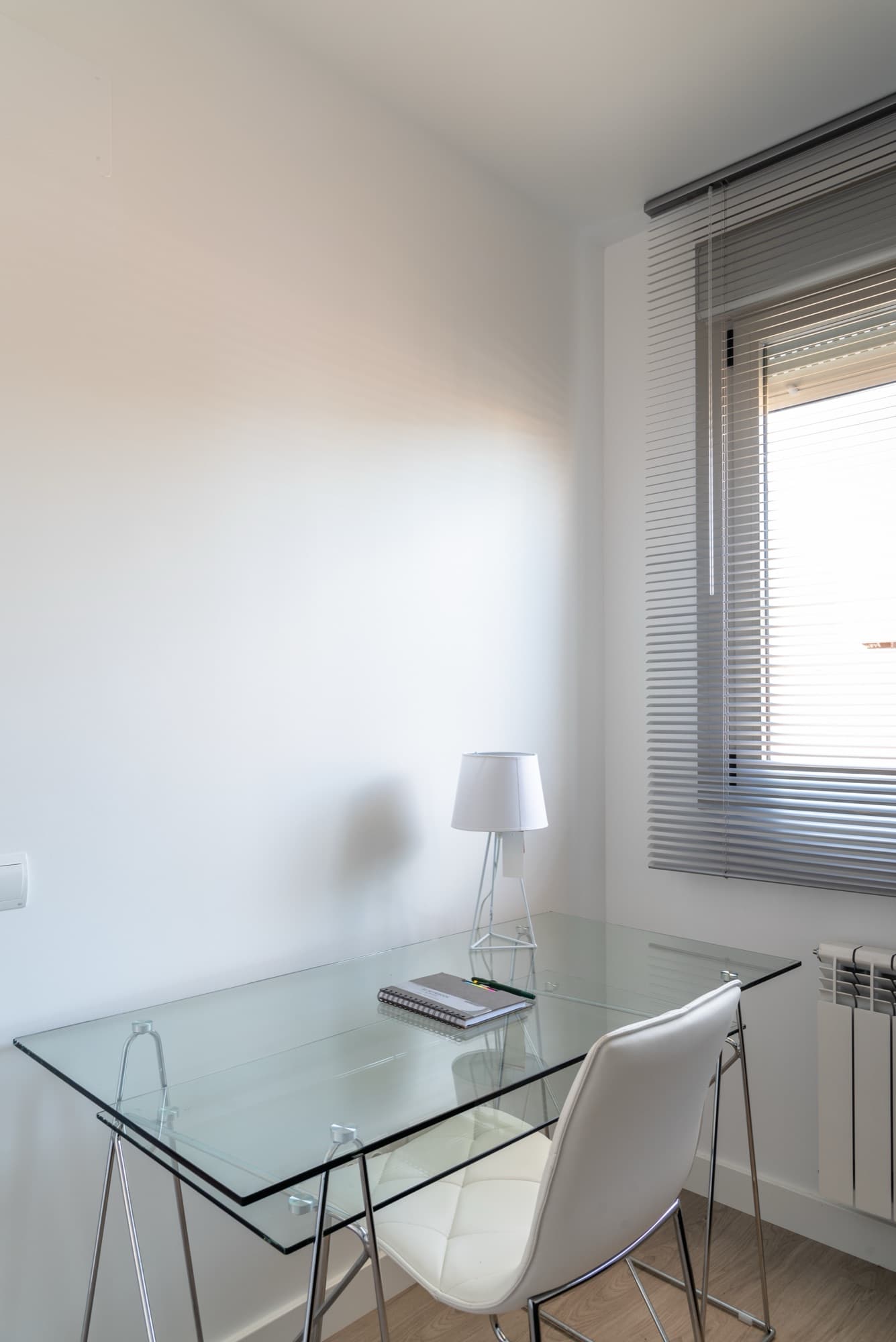 Bright minimal interior with a glass desk beside a floor-to-ceiling window — precision glass & aluminium work.